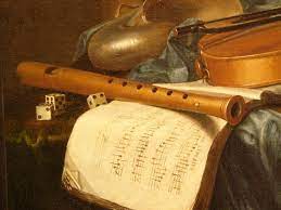 Renaissance recorder lying on top of a sheet of music. Various early instruments in the background
